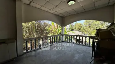 Spacious balcony with lush garden views in a serene residential setting.