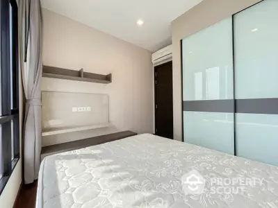 Modern bedroom with large window and built-in shelves in a stylish apartment.