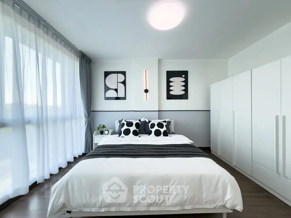 Modern bedroom with stylish decor and ample natural light