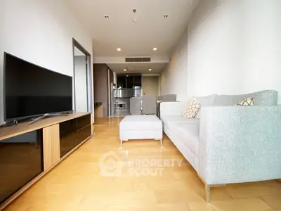 Spacious modern living room with sleek furniture and open kitchen layout.