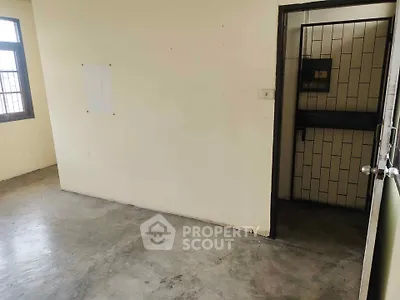Spacious empty room with concrete floor and large window, ideal for customization.