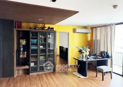 Stylish living room with wooden flooring and vibrant yellow accent wall