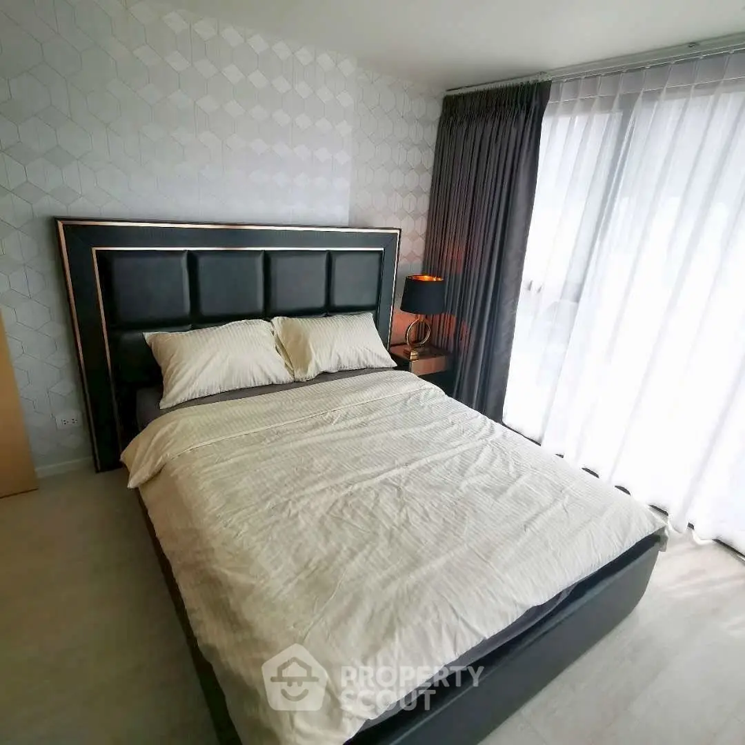 Modern bedroom with stylish decor and large window for natural light.