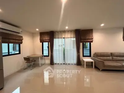 Spacious modern living room with sleek furniture and large windows for natural light.