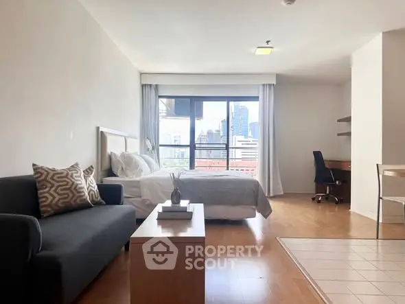 Spacious studio apartment with city view, modern furnishings, and natural light.