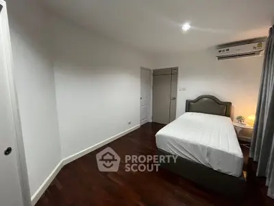 Spacious bedroom with wooden flooring and modern decor
