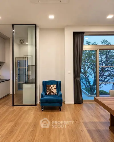 Modern living room with elegant blue armchair and large window view