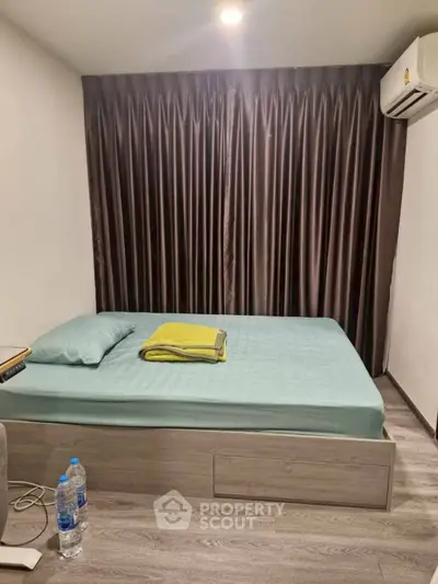 Cozy bedroom with modern decor and air conditioning, perfect for relaxation.