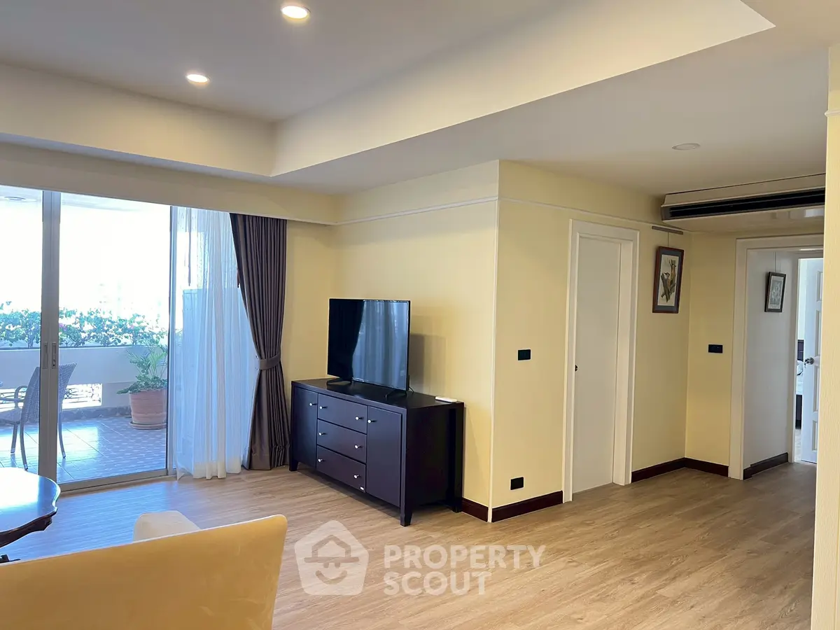 Spacious living room with modern decor and large balcony access.