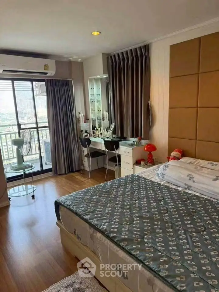 Spacious bedroom with balcony access and modern decor in a high-rise apartment.