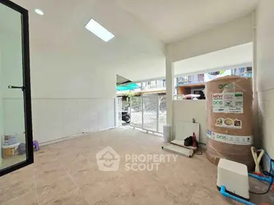 Spacious interior area with tiled flooring and large water tank, ideal for storage or utility use.