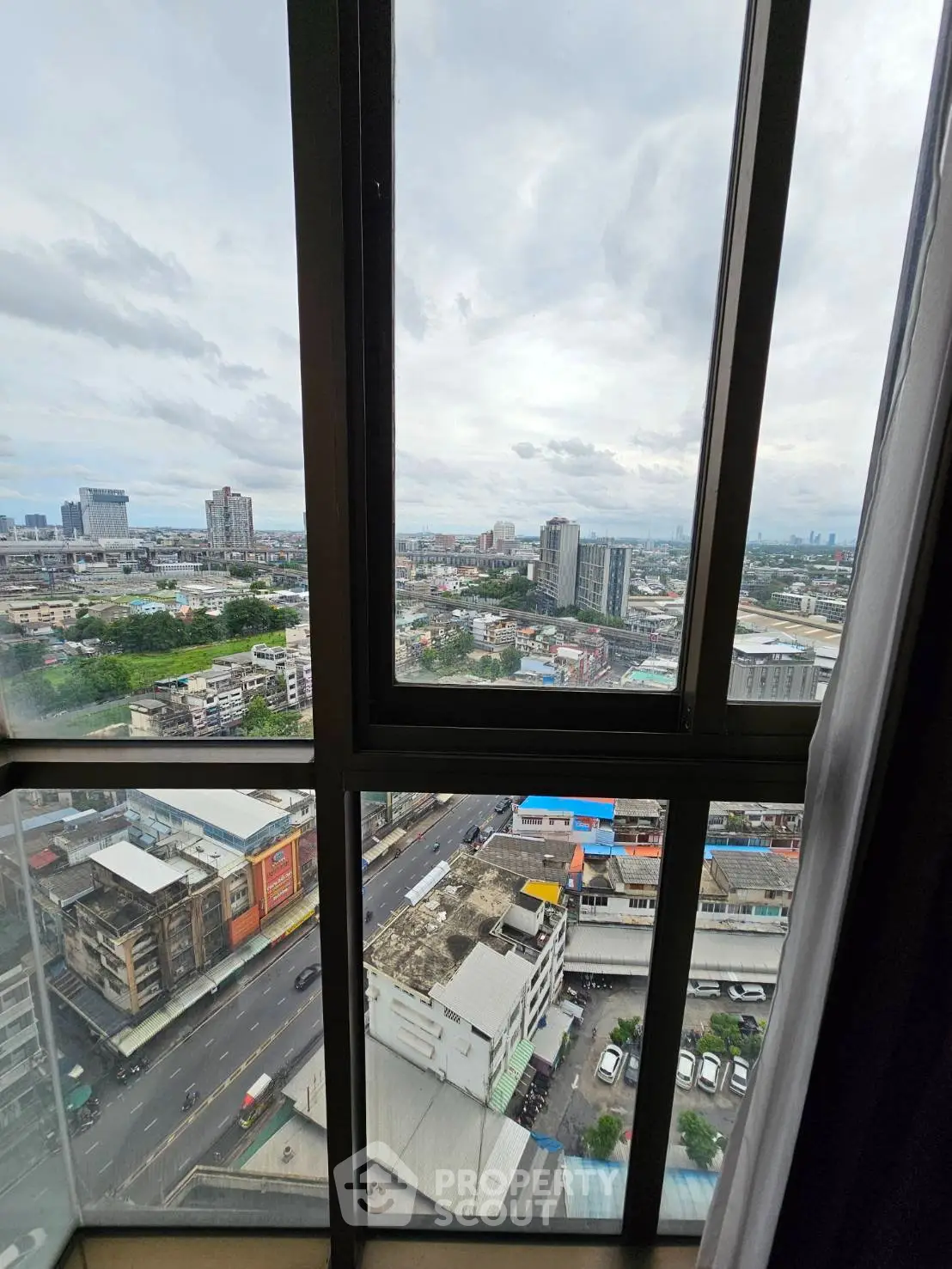 Stunning cityscape view from high-rise apartment window showcasing urban skyline and vibrant city life.