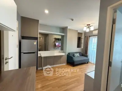 Modern living room with sleek design, featuring a cozy sofa, flat-screen TV, and stylish kitchen area.