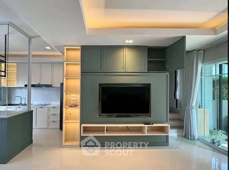 Modern living room with built-in TV unit and open kitchen layout