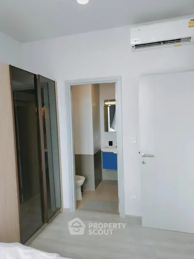 Modern bedroom with ensuite bathroom and sleek air conditioning unit