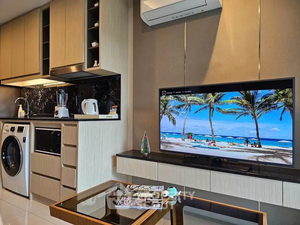 Modern living room with integrated kitchen and appliances, featuring a sleek design and tropical decor.