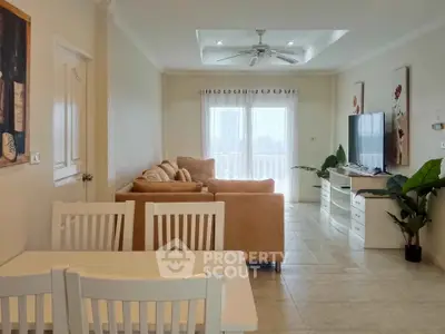 Spacious living room with cozy seating and natural light, perfect for relaxation and entertainment.