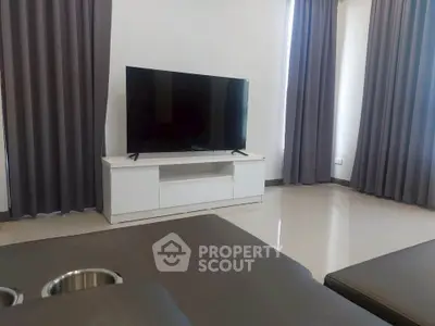 Modern living room with sleek TV setup and elegant curtains.