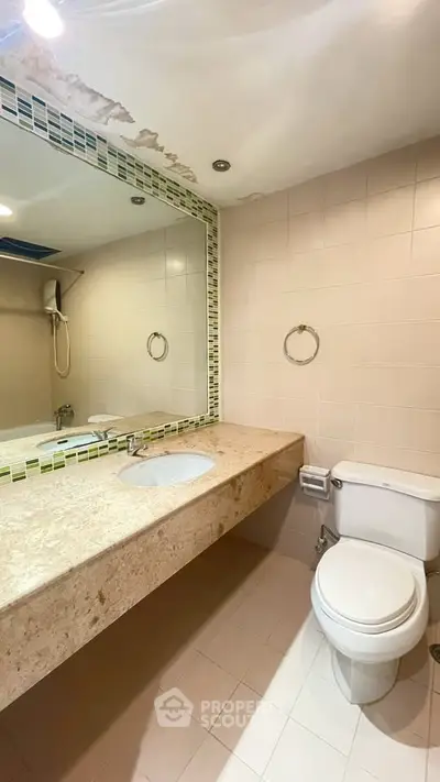 Spacious bathroom with large mirror and modern fixtures in a stylish real estate property.