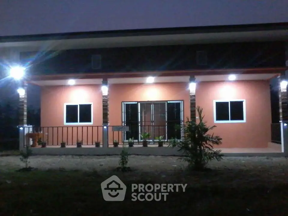 Charming single-story home with illuminated porch and modern design.