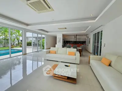 Spacious modern living room with pool view and open kitchen layout