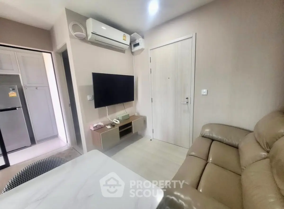 Cozy living room with modern furniture and wall-mounted TV in a stylish apartment.