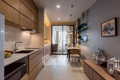 Modern kitchen with sleek cabinetry and open layout leading to dining area.