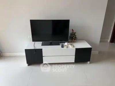 Modern living room with sleek TV stand and flat-screen television.