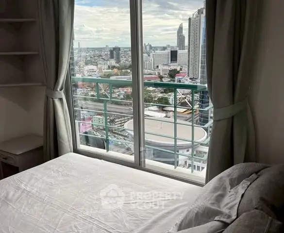Stunning city view from a modern bedroom with large window and cozy bed.