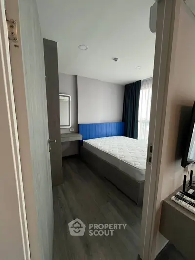 Modern bedroom with stylish decor and natural light, featuring a comfortable bed and sleek flooring.