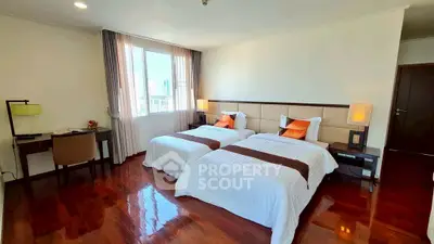 Spacious bedroom with twin beds and elegant decor, perfect for comfort and relaxation.