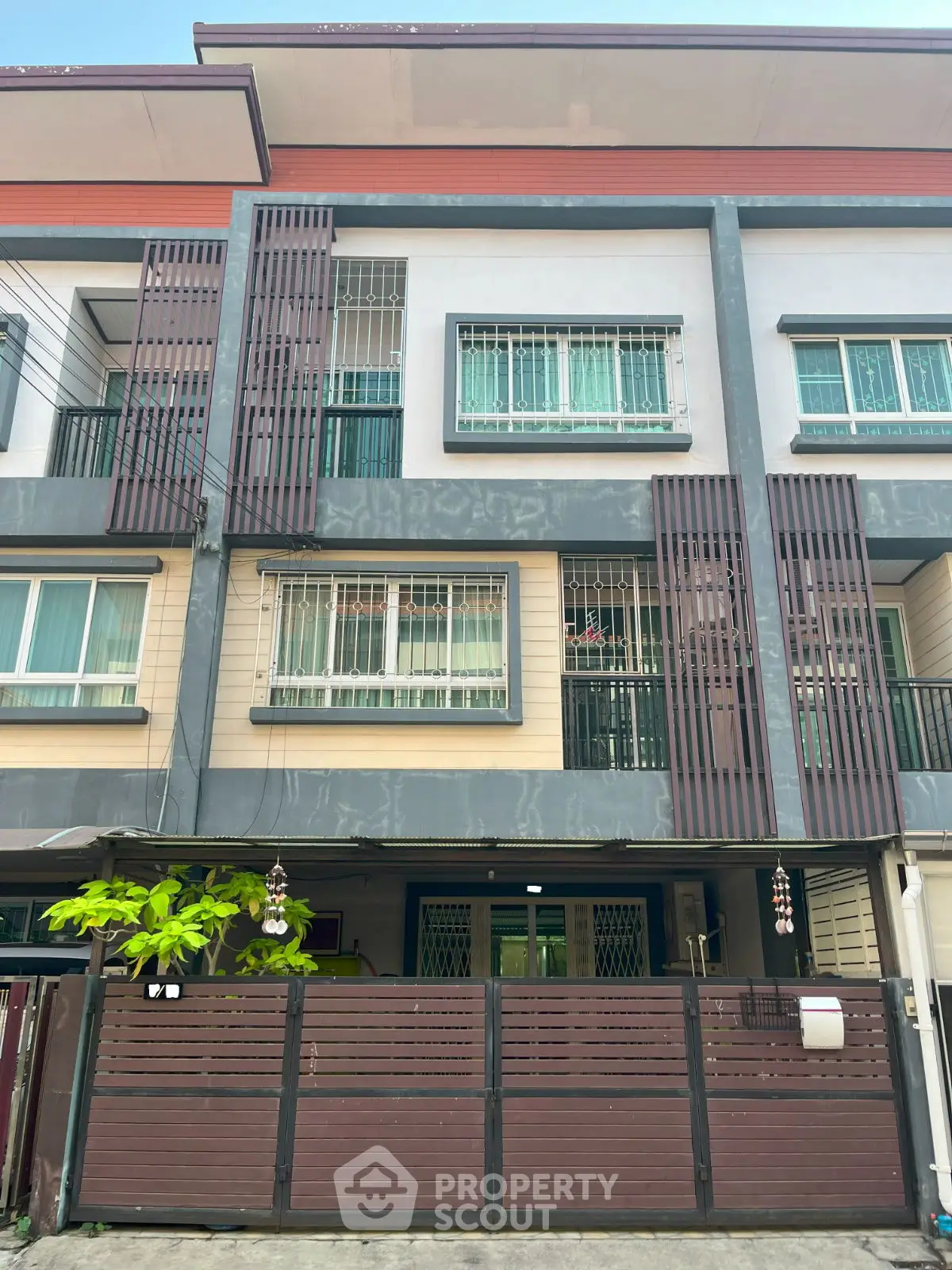 Modern townhouse exterior with stylish facade and secure gated entrance.