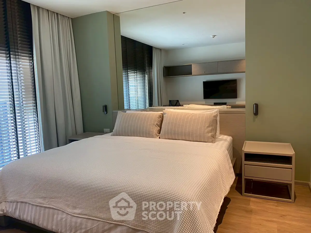 Modern bedroom with stylish decor and large windows for natural light.