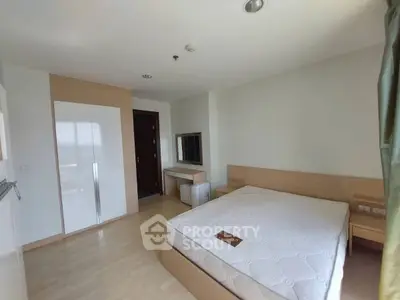 Spacious bedroom with modern design and ample natural light, featuring a comfortable bed and sleek wardrobe.