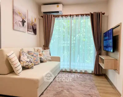 Cozy living room with modern decor, large sofa, wall-mounted TV, and natural light from window.
