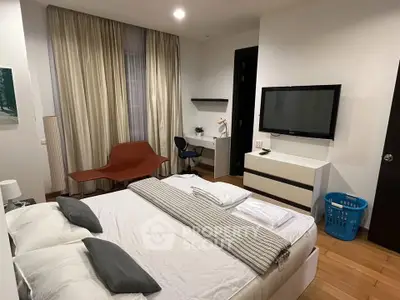 Spacious modern bedroom with stylish decor and cozy ambiance, featuring a large bed and wall-mounted TV.