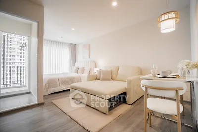 Modern studio apartment with cozy living area and elegant decor, featuring a large window with city view.