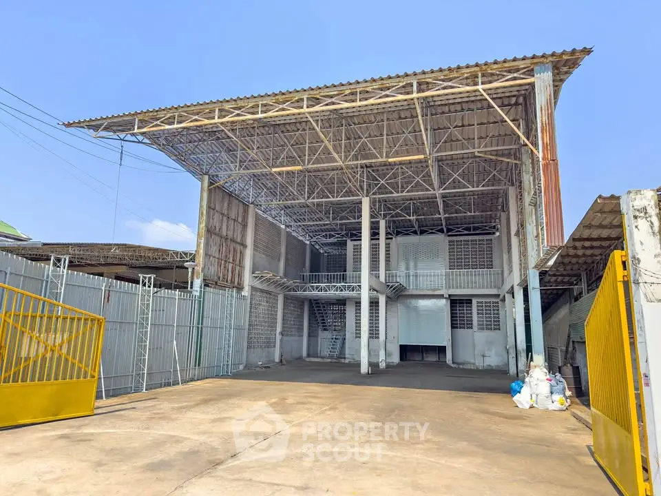 Spacious industrial warehouse with high ceilings and gated entrance