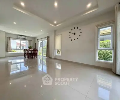 Spacious modern living room with large windows and elegant dining area, perfect for family gatherings.