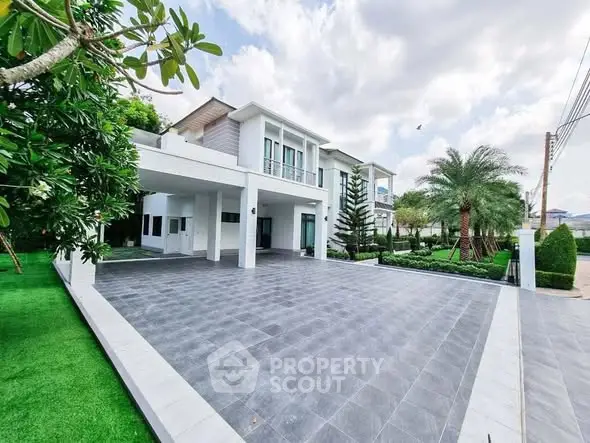 Stunning modern home with spacious driveway and lush landscaping, perfect for luxury living.