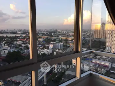 Stunning cityscape view from high-rise apartment window at sunset.