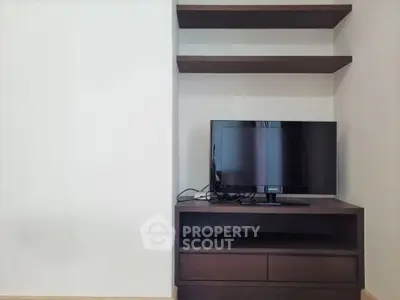 Modern living room with sleek TV stand and wall-mounted shelves.
