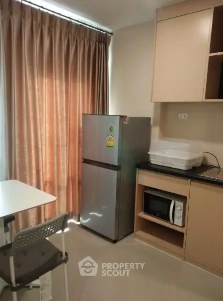 Modern kitchen with stainless steel fridge and microwave in cozy apartment