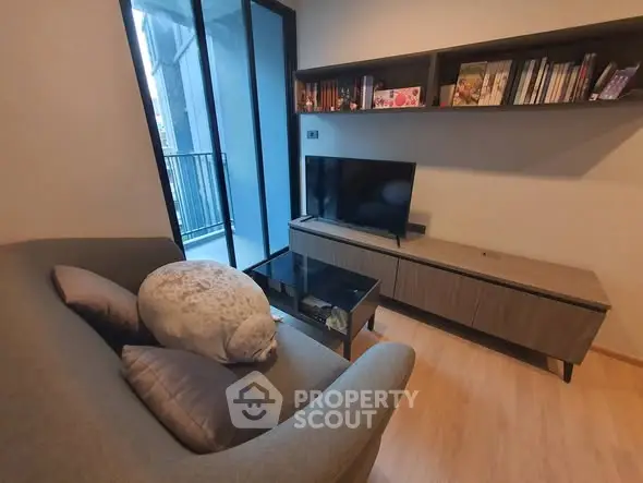 Cozy living room with modern TV setup and balcony view
