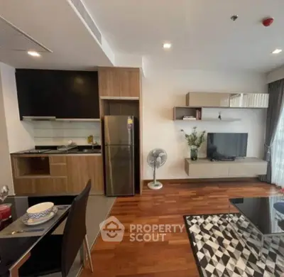 Modern living room with open kitchen, hardwood floors, and stylish decor in a contemporary apartment.
