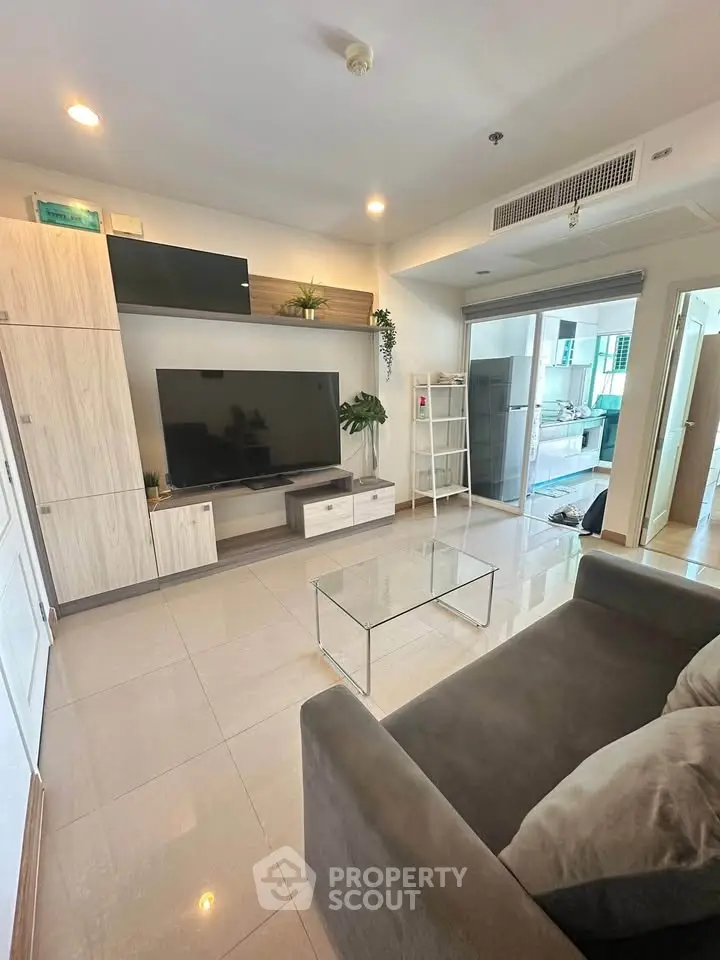 Modern living room with sleek furniture and large TV, perfect for relaxation.