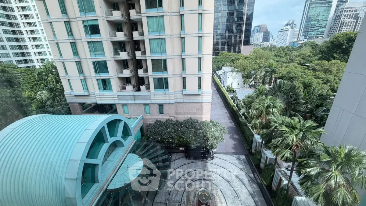 Stunning cityscape view from high-rise building with lush greenery and modern architecture.