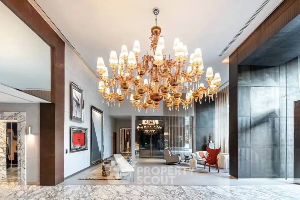 Luxurious lobby with grand chandelier and elegant marble flooring in upscale building.