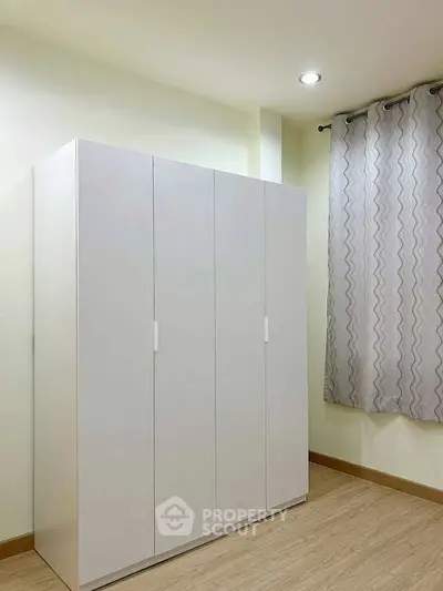 Spacious bedroom with modern wardrobe and elegant curtains, perfect for stylish living.