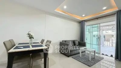 Modern living room with dining area and balcony access in a stylish apartment.